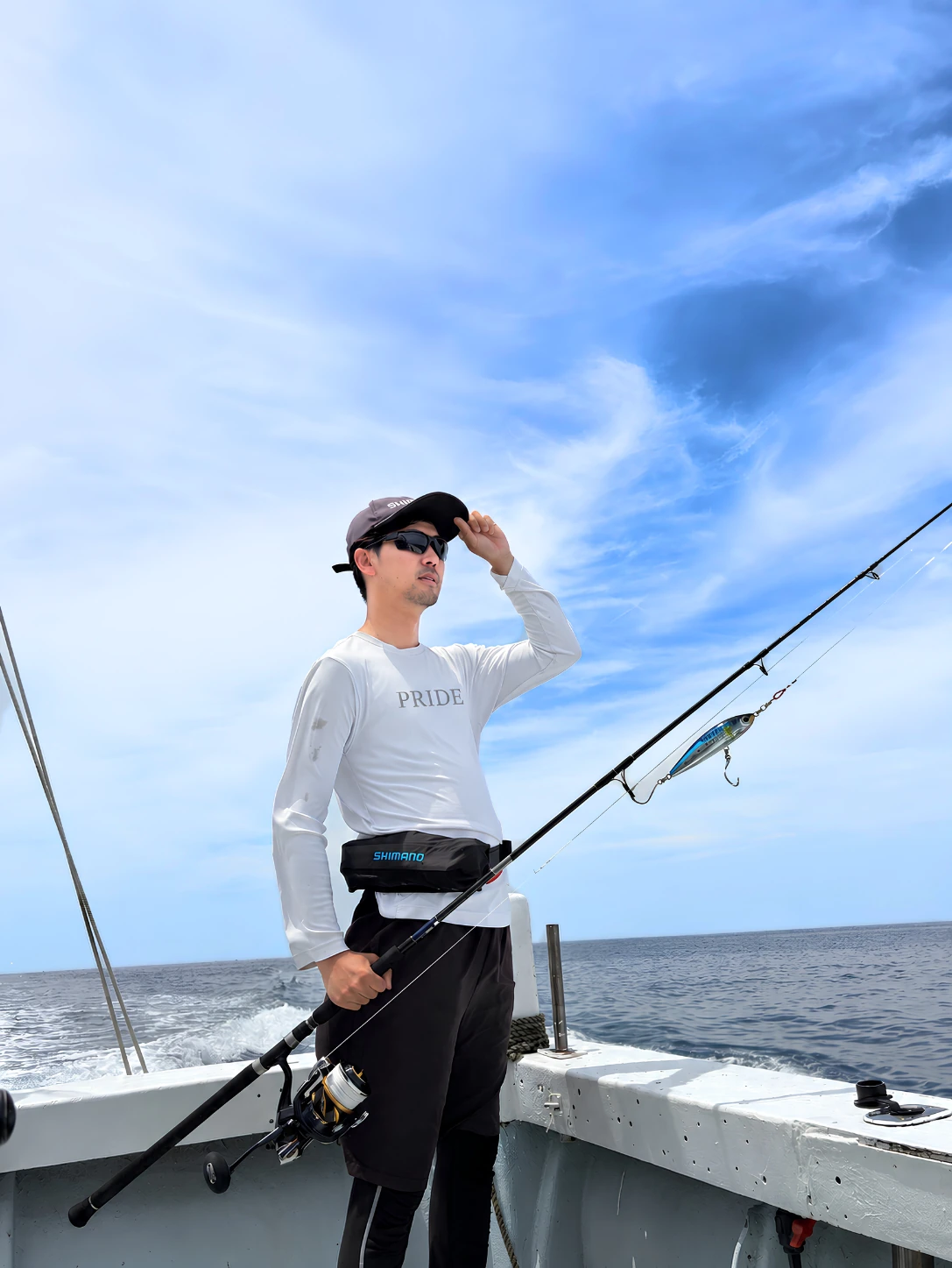 船上で釣り竿を持つPRIDE FISHING SHOPオーナーの近藤明